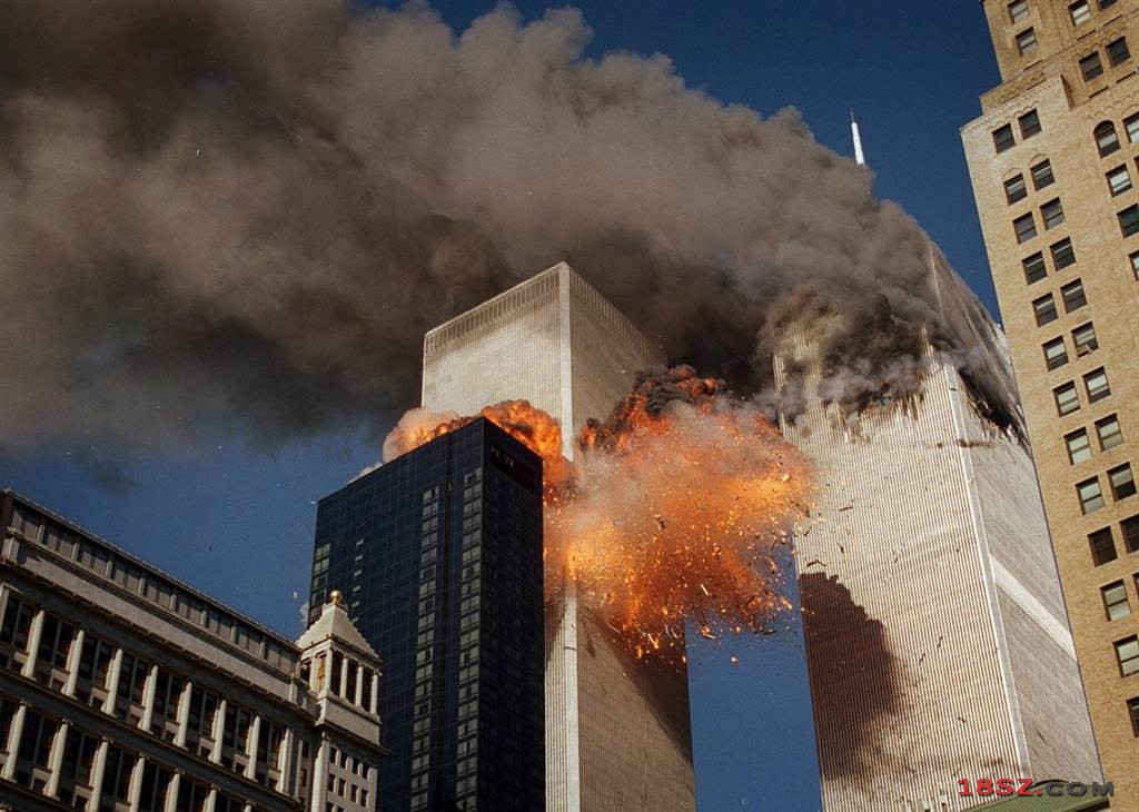 飞机撞上双子星大楼后，火焰及残骸从第二栋大楼炸开，大楼冒出浓烟。（图／美联社）